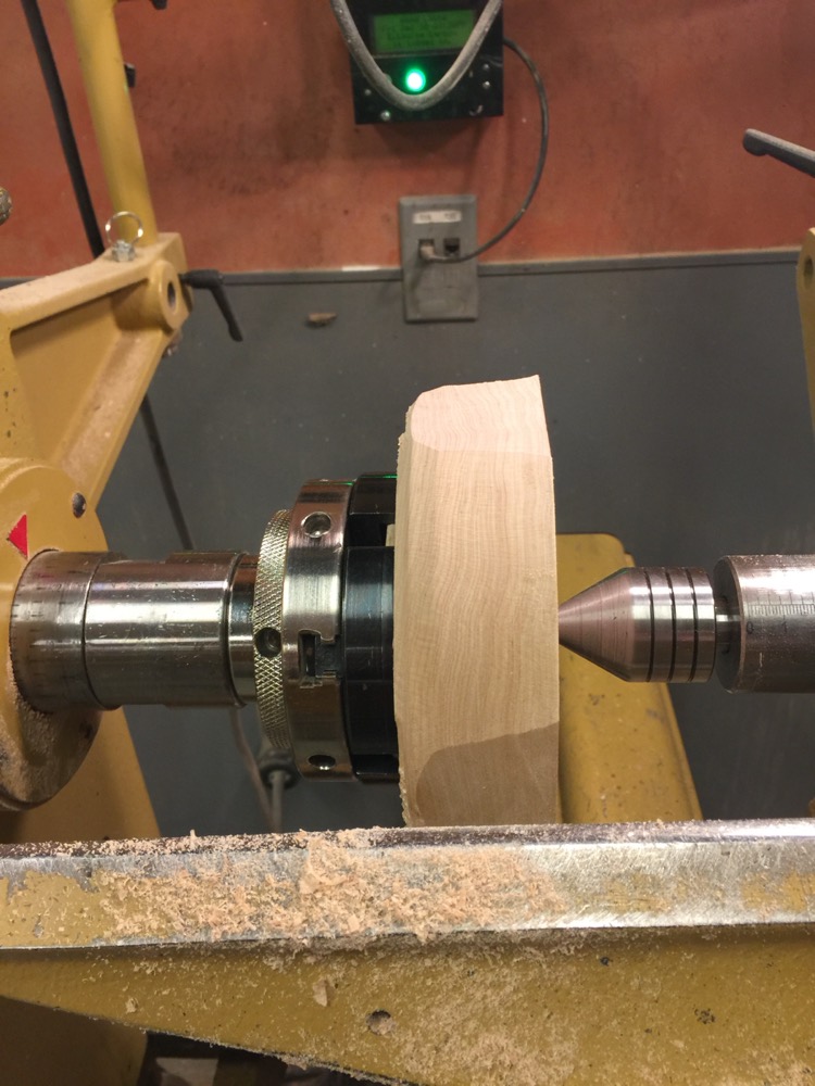 A wooden bowl being turned on a lathe.