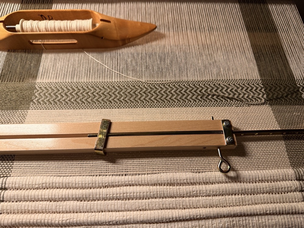 Woven tea towels and textiles on a floor loom.